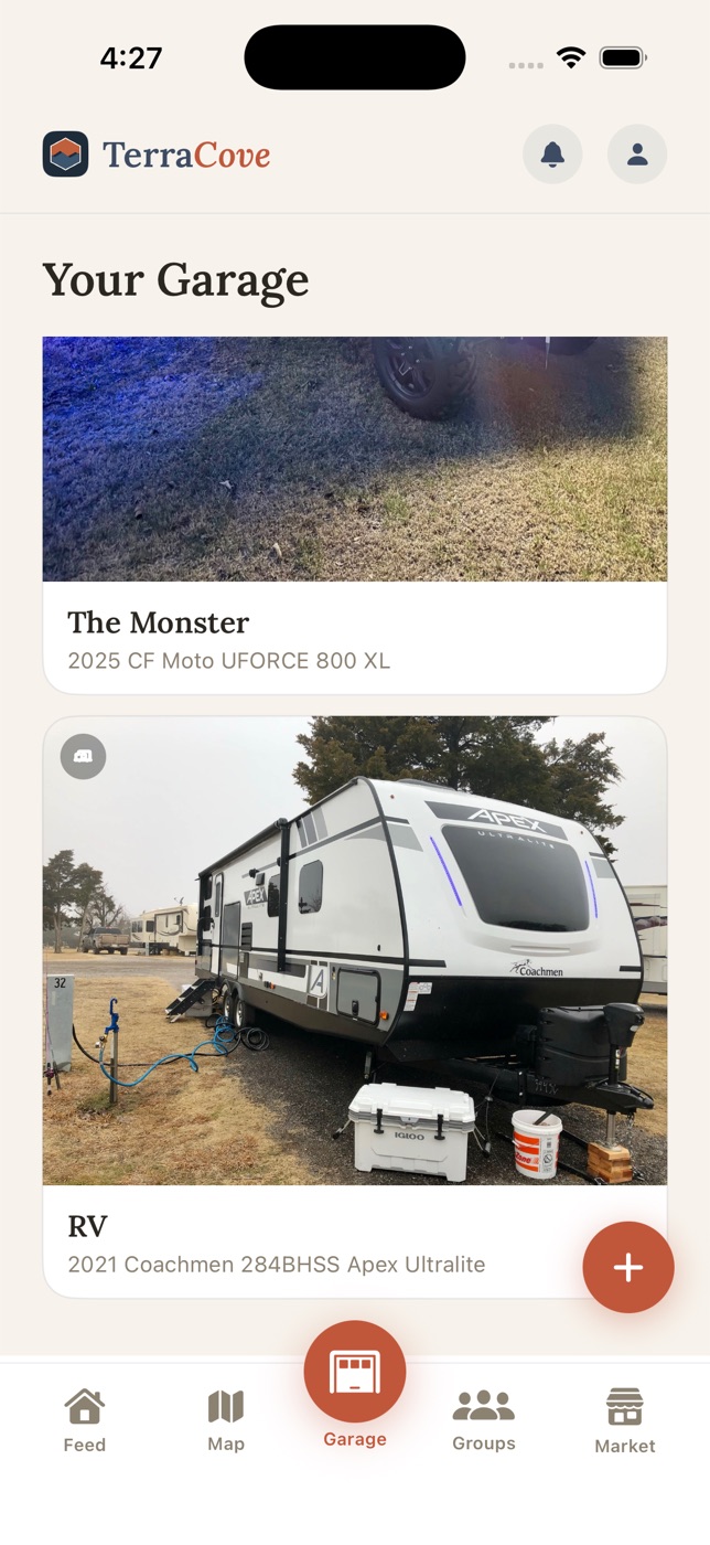 A garage holding two vehicles from different categories: an off-road side-by-side and a travel trailer.
